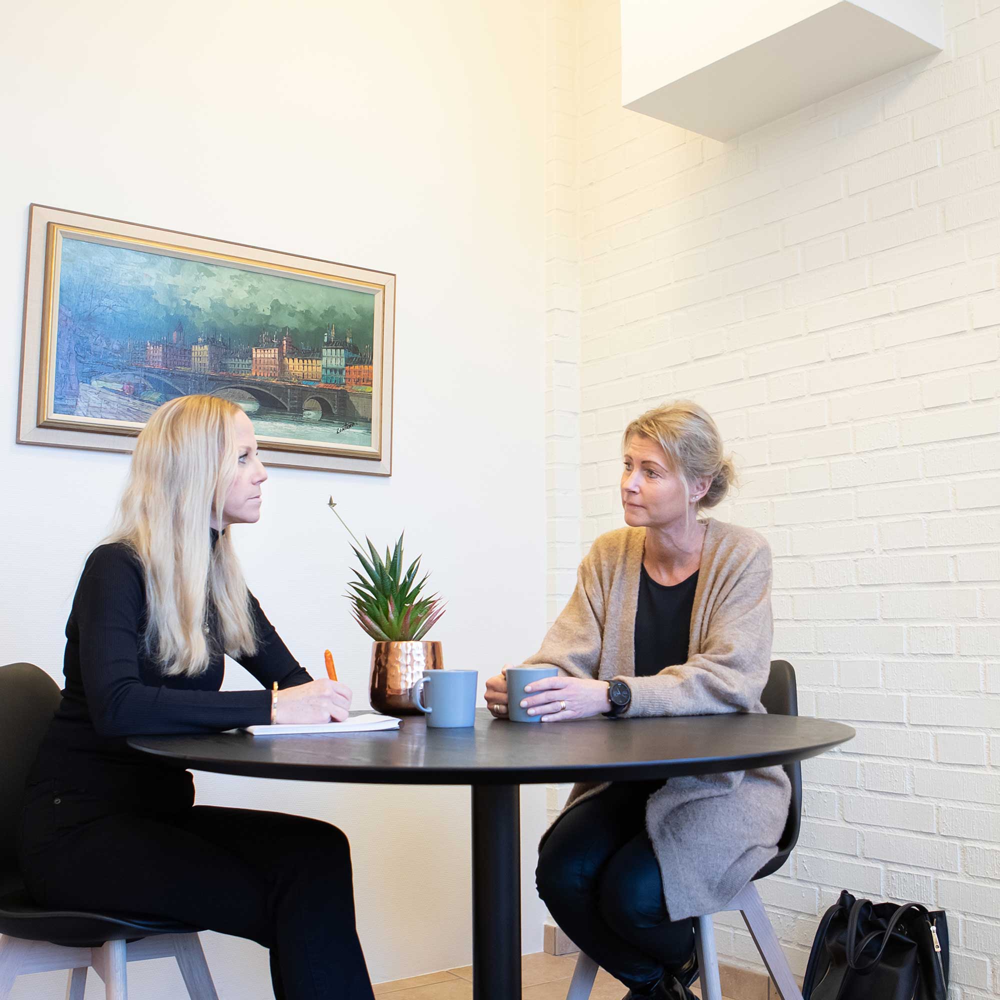 vår rådgivare Maria martinsson i samspråk med en kund. de sitter vid ett runt bord.
