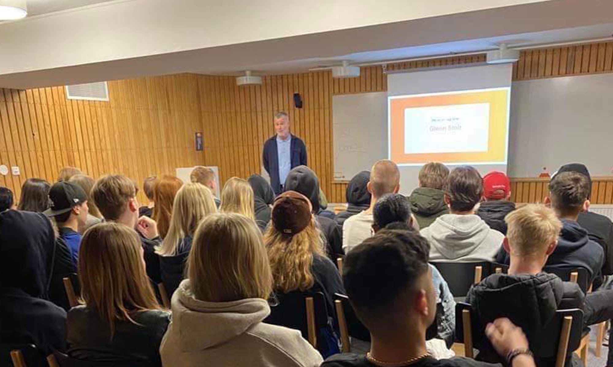 en bild på en mängd elever som lyssnar till ekonomisk information av en rådgivare