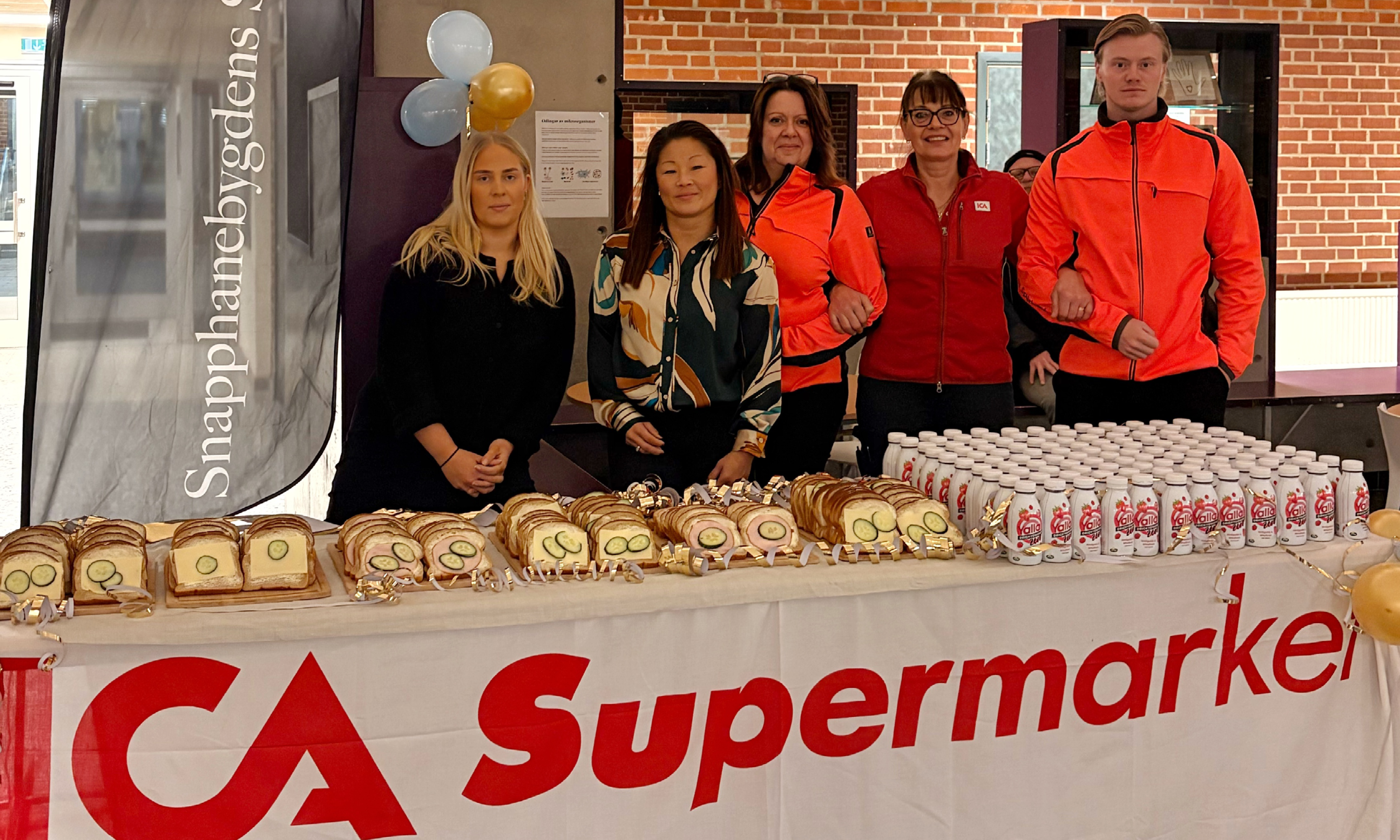 bild på personal från Bjärnums skola, ICA i Bjärnum och banken. Framför personerna är frukost uppdukad.