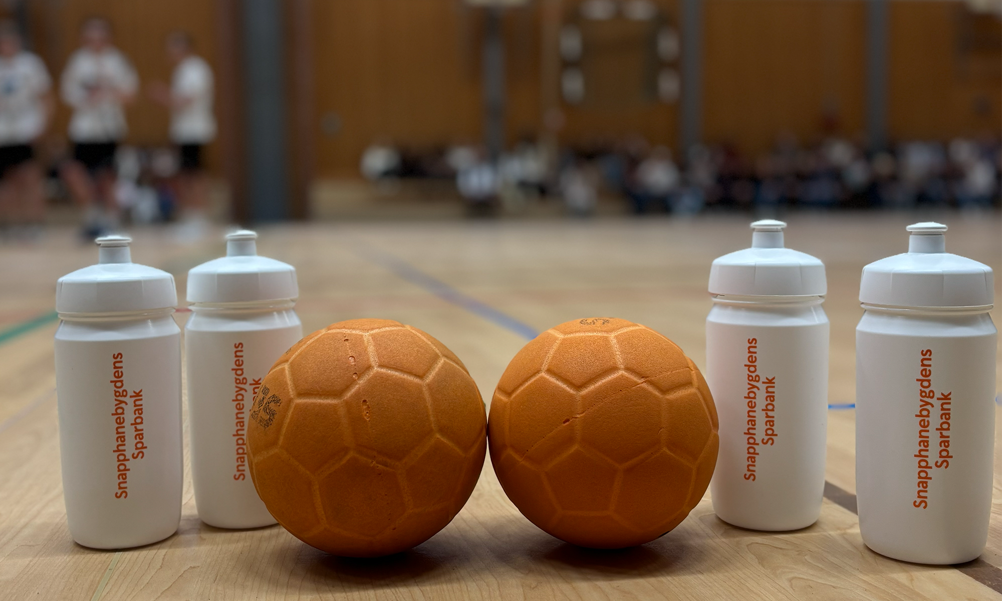 en bild på 2 handbollar och några vattenflaskor med bankens namn på.